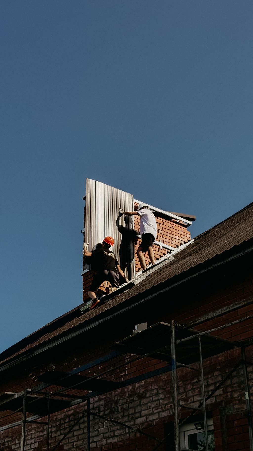 Roofers working on a metal roof